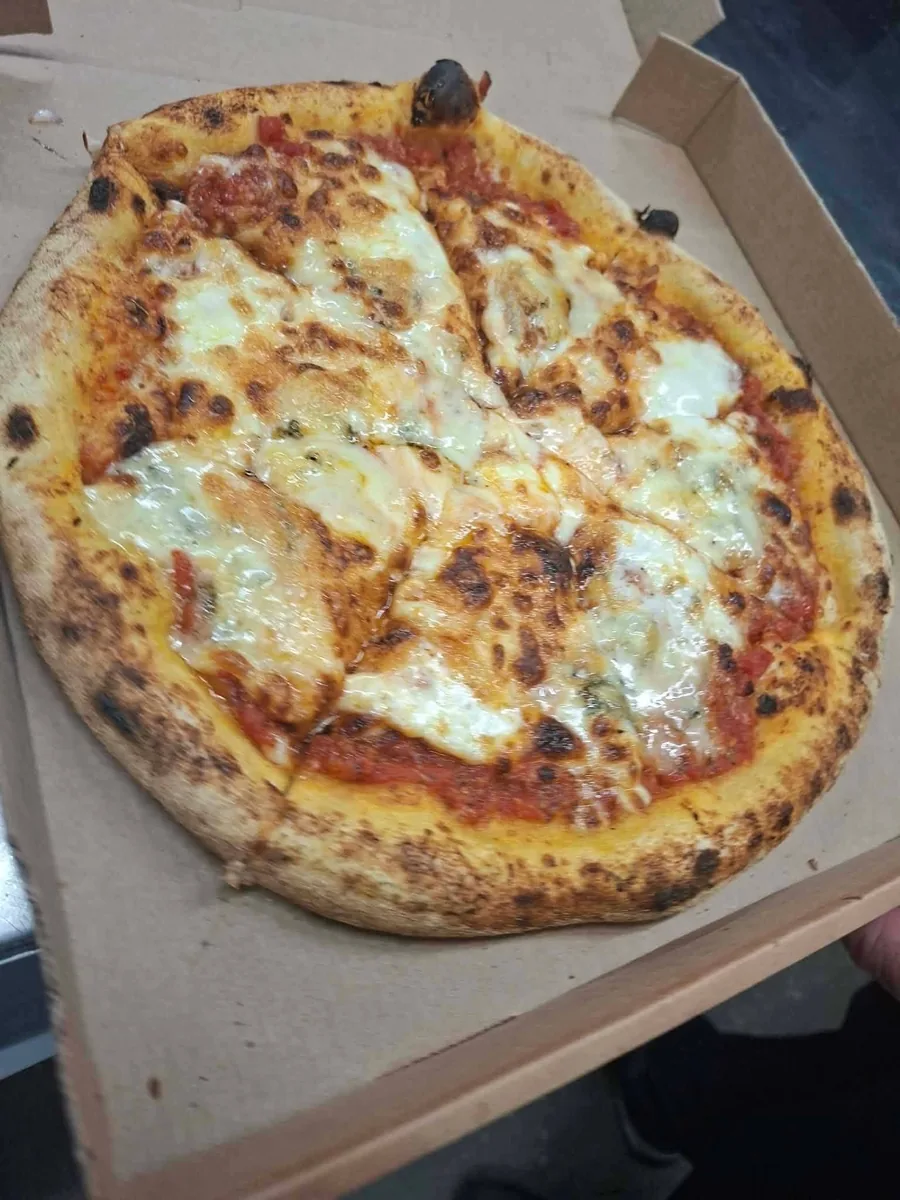 Pizza margherita, mozzarella fondante et bords boursouflés au feu de bois
