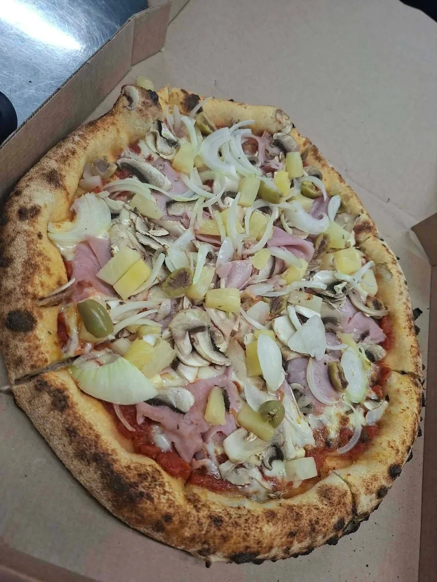 Pizza garnie de jambon, champignons, oignon et ananas